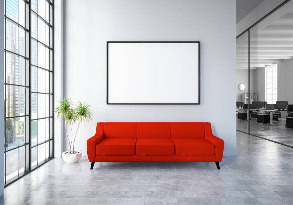 Waiting room with empty picture frame and red sofa